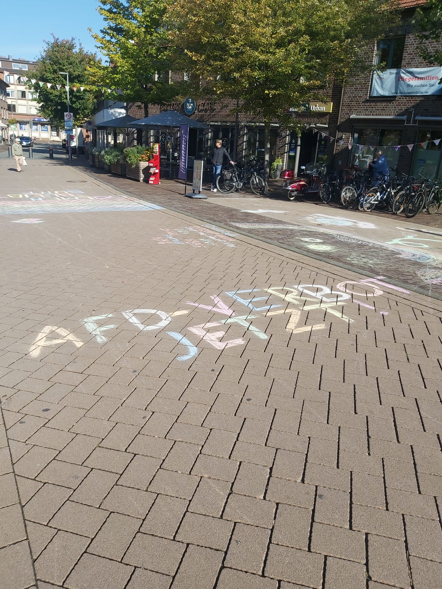 Mit Kreide beschriebene Straße gegenüber dem AfD-Infostand in Dülmen